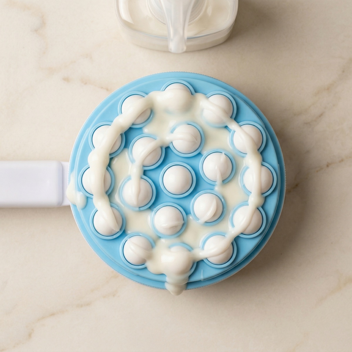 Applicator loaded with lotion showing even distribution across rollers